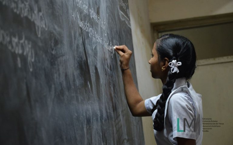 Latin girl writes on back board & LM Abogados logo